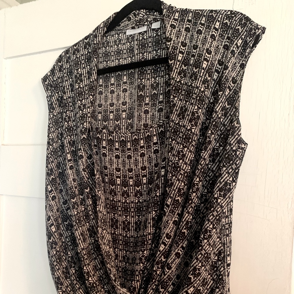 Sleeveless, semi sheer and draping piece will compliment any body type.